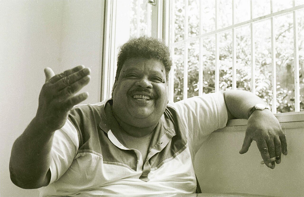 Tim Maia sorrindo, sentado, em foto de 1987