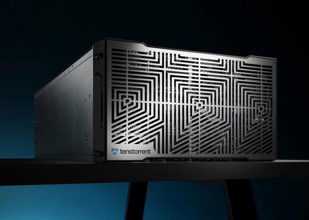 Servidor preto da Tenstorrent com grade frontal metálica de desenho geométrico, apoiado numa mesa contra fundo azul-escuro