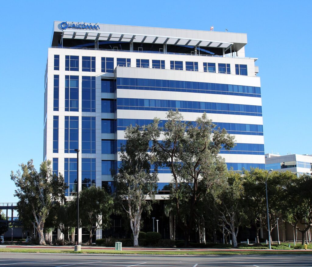 Prédio da sede da Qualcomm em La Jolla, San Diego, com fachada branca e azul e árvores à frente