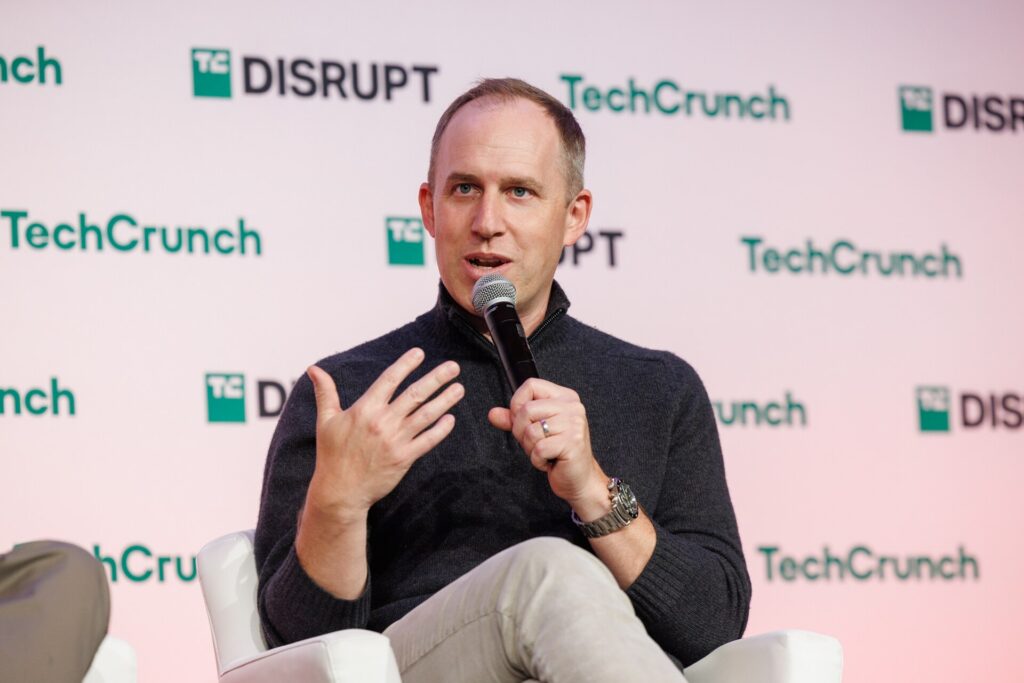 Bret Taylor, cofundador da Sierra, falando ao microfone no palco do TechCrunch Disrupt 2024